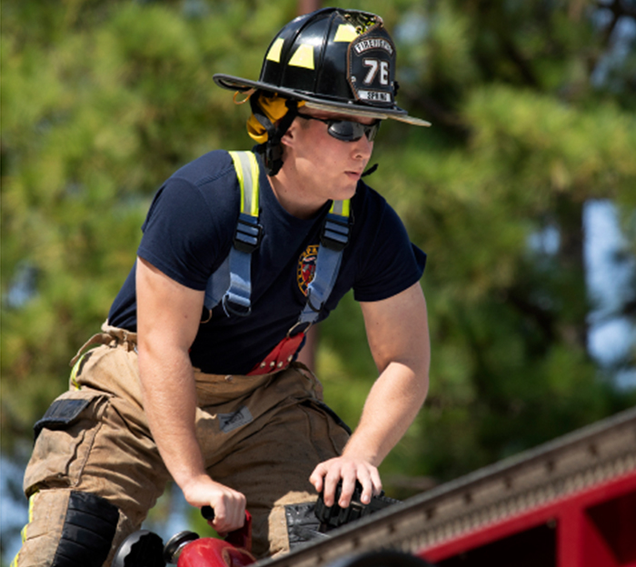 Firefighter working on top of fire truck