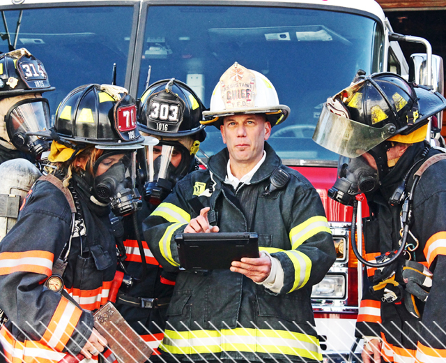 Large group of firefighters looking at tablet