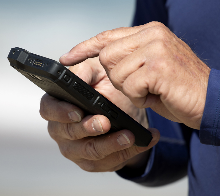 Hand closeup tapping with finger on black mobile device