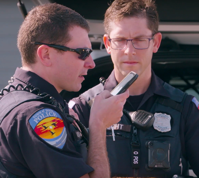 Law enforcement officers listening to mobile device