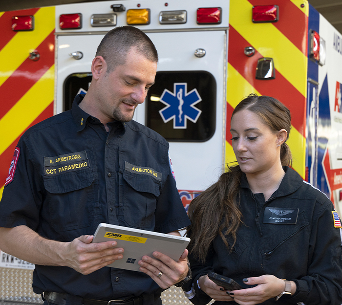 Two EMS workers looking at tablet