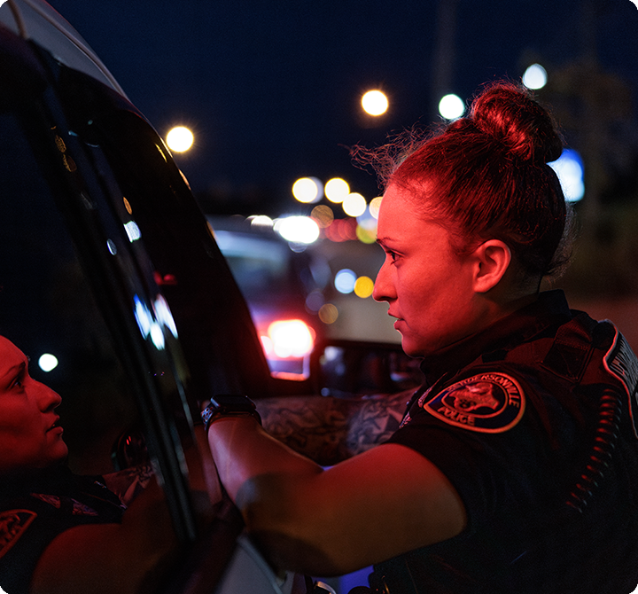 Police officer leaning on vehicle