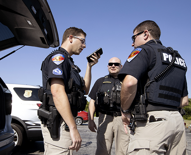 Officers with the town of Duck, NC, police department outside their vehicles. The town is on FirstNet, benefitting from the platform’s reliability, connectivity, and operability during everyday operations as well as during emergencies such as hurricane evacuations. 