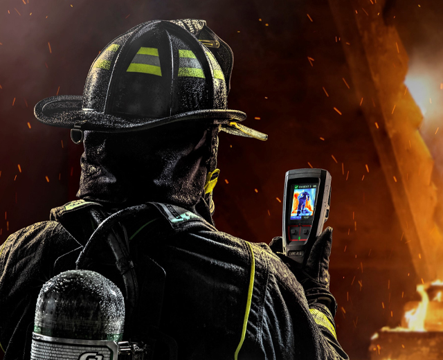 Firefighter in the middle of fire holding Lunar search device.