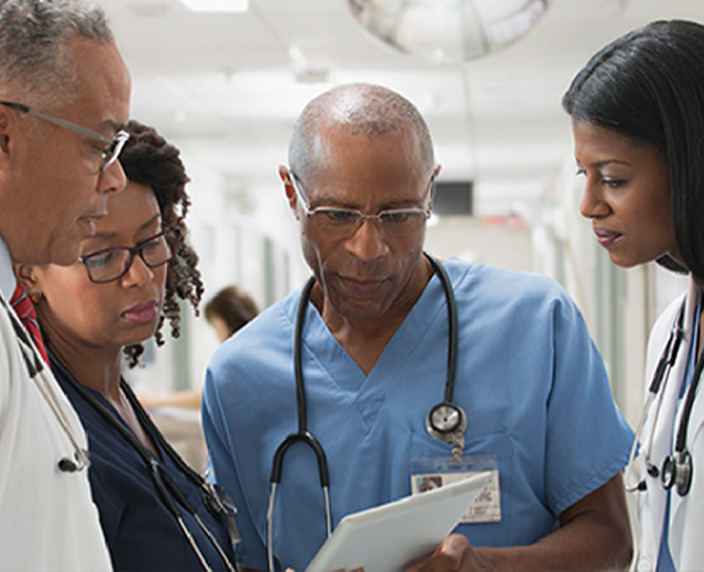 Group of medical professionals looking at a tablet
