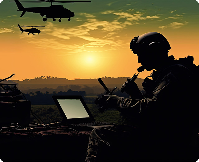 National Guard soldiers in the field using firstnet devices with helicopters in background