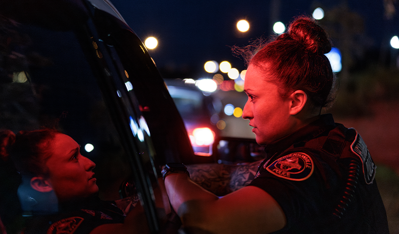 Police officer leaning on vehicle