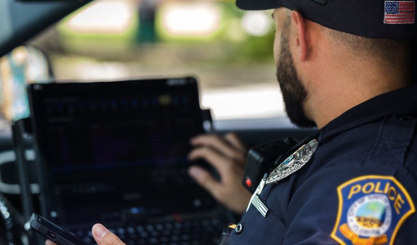 Officer using laptop in vehicle