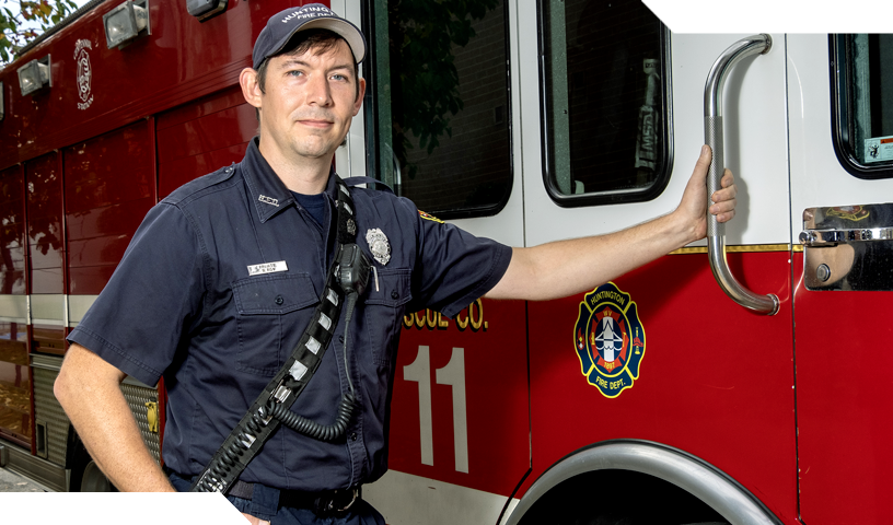 Sam Roy - Firefighter standing next to truck