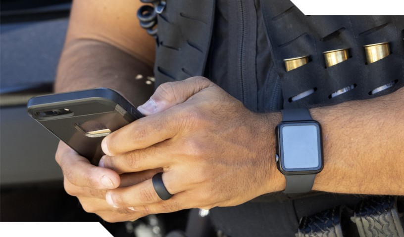 Close-up of law enforcement holding phone with smart device on his wrist