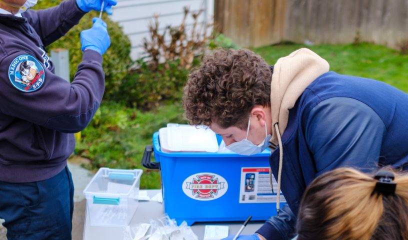 Young man with mask on registers for immunization