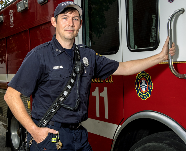 Firefighter standing next to truck